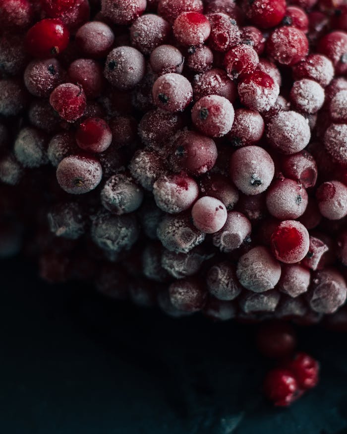 Frosted red berries piled high, showcasing freshness and natural vibrancy.